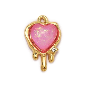 Macro shot of pink heart pendant with gold drip effect and sparkling rhinestone inlay
