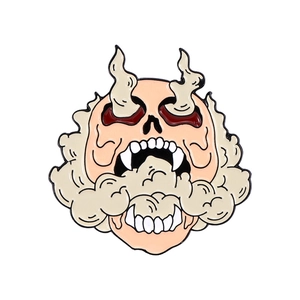 Detail shot of a punk gothic skull enamel pin with beige smoke and dark red accents