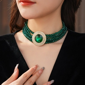 Detail of emerald green bead choker with a large oval rhinestone pendant on model