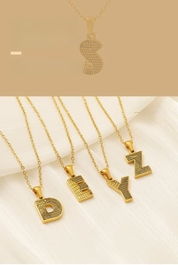 Gros plan du collier plaqué or avec une texture nid d'abeille unique sur le pendentif lettre