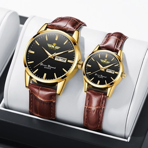 Close-up of gold quartz watches with black dials and brown leather straps in a gift box