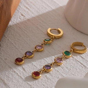 Detail of gold fringe earrings with red purple pink and green zircon stones