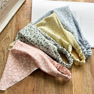 Set of four floral chiffon headbands in pink, green, yellow and blue on wood background
