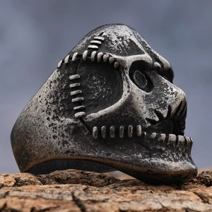 Dettaglio dell'anello teschio argento vintage con cicatrici cucite e stile punk rock