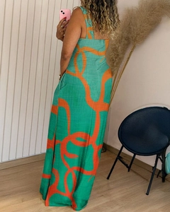 Detail view of back of a green sleeveless maxi dress with orange abstract patterns