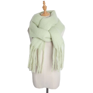 Detail of light green mohair knit scarf with fringe tassels on model
