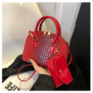 Detail of red crocodile pattern shell bag with matching small coin purse and gold zippers