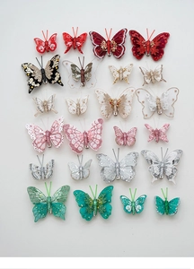 Detailed view of colorful glitter fabric butterfly ornaments with pearls and metal clips