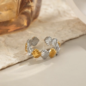 Detail eines verstellbaren geometrischen Muschelrings in Gold und Silber mit Textur