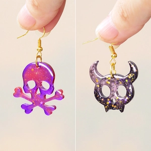 Glittering skull and horned skeleton earrings with purple gradients for Halloween DIY