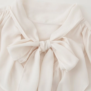 Elegant off-white chiffon blouse featuring a tie-neck bow and ruffled collar detail