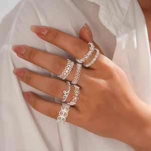 Elegant hollow floral silver rings set worn by model with minimalist lace patterns