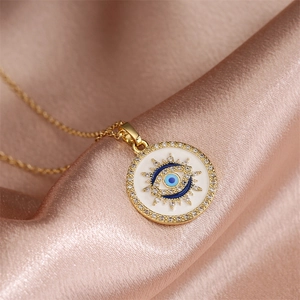 Macro detail of gold evil eye pendant with blue enamel and sparkling rhinestones