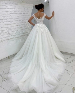 Detail of bridal gown with floral lace embroidery and elegant pearl buttons on open back