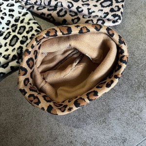 Detail of interior stitching and knit structure on a leopard print winter hat
