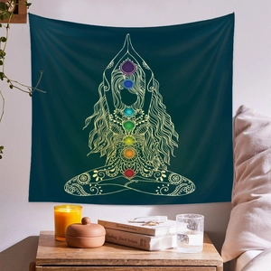 Detail of teal yoga tapestry with gold chakra design hanging over a bedside table