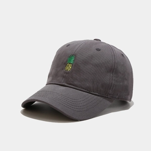 Close-up of a dark grey cotton baseball cap with a detailed yellow pineapple embroidery