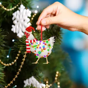 Detail of chicken Christmas ornament with scarf and hat on a decorated tree branch