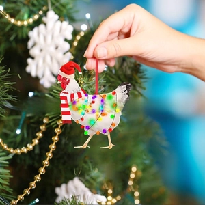 Detail of chicken Christmas ornament with scarf and hat on a decorated tree branch