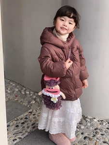 Detail of a handmade purple crochet monster crossbody bag for children on winter outfit