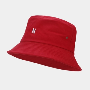 Détail de la broderie lettre N blanche sur un chapeau bob en toile rouge robuste