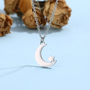 Detail of silver moon and star pendant necklace on a blue background with soft lighting