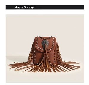 Detailed view of brown leather crossbody bag with skull studs and long side fringes