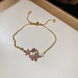 Macro view of adjustable snake chain bracelet with purple crystal flower charms