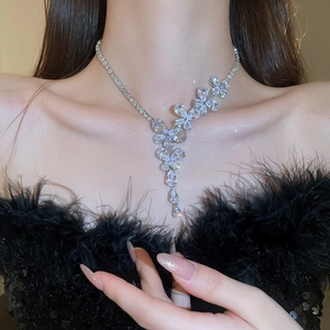 Dettaglio di una collana a farfalla in argento con zirconi e ciondoli a goccia
