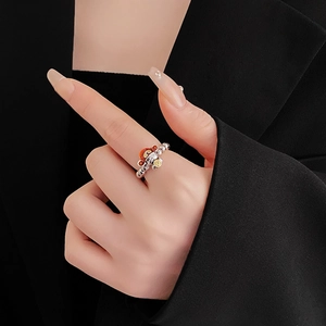 Close-up of beaded silver dragon ring with colorful enamel dragon charm on model