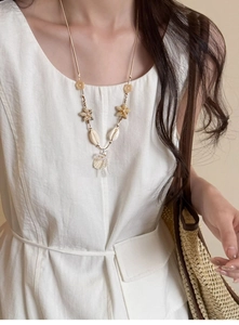 Detailed view of starfish shell and pearl pendant necklace for beach vacations