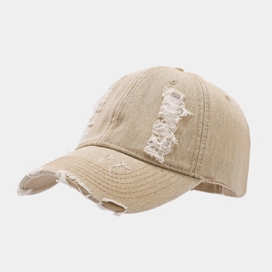 Gros plan détaillé des finitions usées et déchirées sur une casquette en denim kaki
