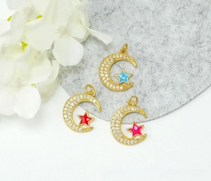 Detail of 18K gold-plated star and moon pendants with micro-pave cubic zirconia and enamel