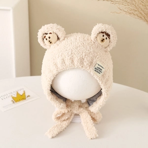 Detailed close-up of plush baby bear hat featuring earflaps and cute bear embroidery