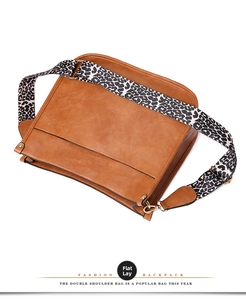 Close-up of brown faux leather tote bag featuring a stylish leopard print wide strap