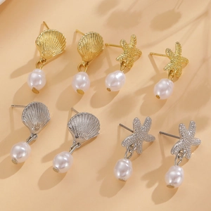 Detailed close-up of shell and starfish stud earrings with white irregular pearl drops