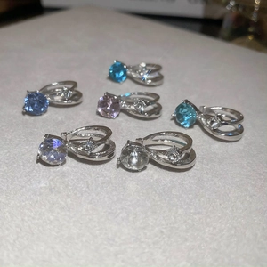 Vue macro de boucles d'oreilles doubles en argent avec zircons ronds colorés
