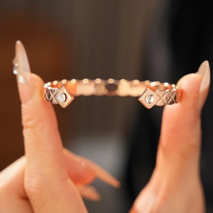 Gros plan détaillé du bracelet jonc doré rose avec texture matelassée et zircons