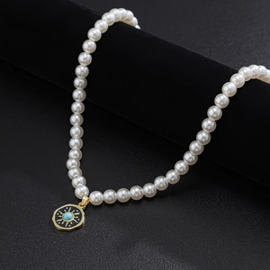 Men's pearl necklace with a sun pendant and turquoise stone on black velvet background