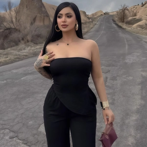 Détail d'un ensemble haut bustier noir et pantalon avec des accessoires de bijoux dorés