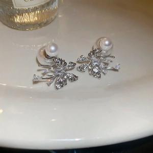 Detailed macro view of butterfly earrings with sparkling crystals and pearl backings