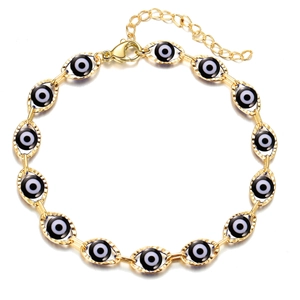 Close-up of golden Evil Eye bracelet featuring blue enamel eyes and adjustable lobster clasp