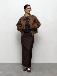 Détail d'une veste à col marron foncé et d'une jupe longue assortie en laine de qualité