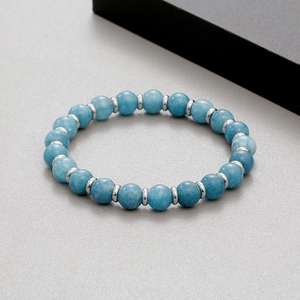 Macro detail of 8mm blue natural stone beads and silver stainless steel spacers on bracelet