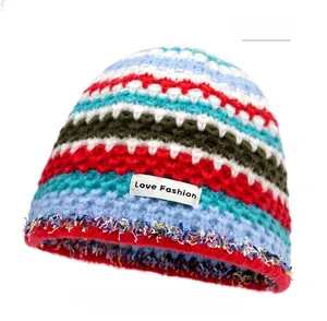 Detail of multi-color striped knit beanie with Love Fashion label and fringe edge