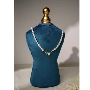 Freshwater pearl necklace with gold heart pendant and OT clasp on blue velvet mannequin
