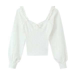 Detail of white ribbed knit top featuring V-neckline with ruffles and a delicate bow tie