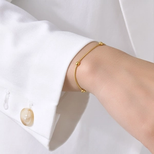 Elegant gold titanium steel ball bracelet featuring a smooth snake chain on a female wrist