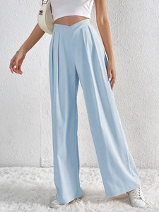 Detail showing high-waist V-cut and vertical pleats on light blue wide-leg trousers