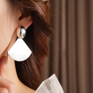 Minimalist silver oval fan-shaped earrings with high-polish finish on female model